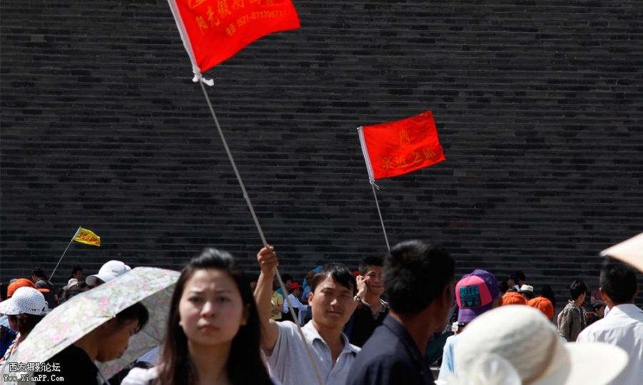 北京前门游客非常多，除了人，一眼看见的是颜色大小各异的导游旗